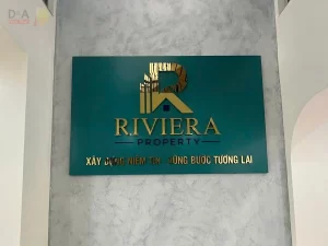 thi công logo inox gương vàng Riviera Property tại không gian đón khách, nâng tầm hình ảnh thương hiệu bởi Nhật Thiên D&A.